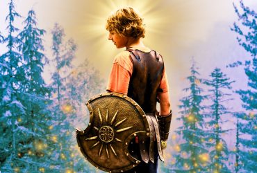 Walker Scobell as Percy Jackson holding a shield with a background featuring trees