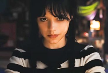 Jenna Ortega as Wednesday Addams wearing a striped shirt and smirking